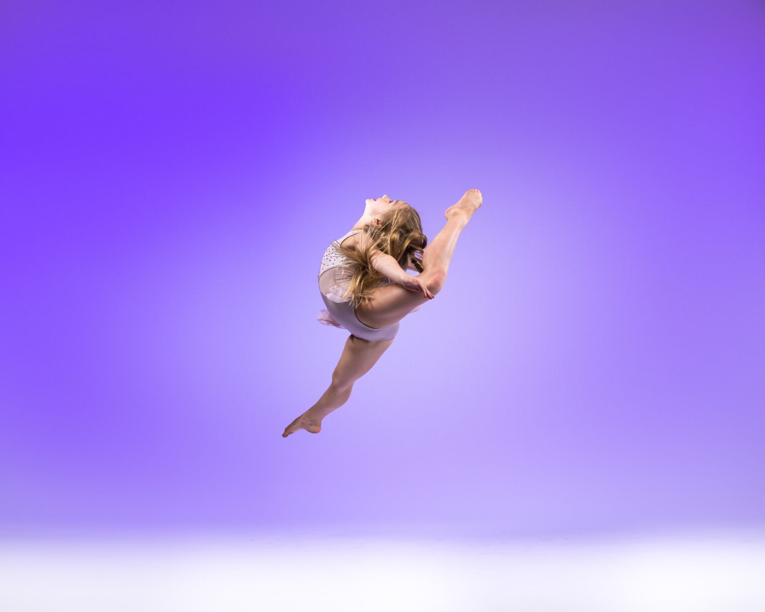 Dancer leaping on a purple backdrop
